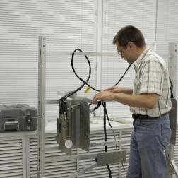 Владислав Третьяков, сотрудник отдела ядерной планетологии ИКИ РАН, устанавливает ДАН на имитатор посадочных мест ровера «Кьюриосити» проекта «Марсианская научная лаборатория» (NASA). 2008 г. Фотография ИКИ РАН