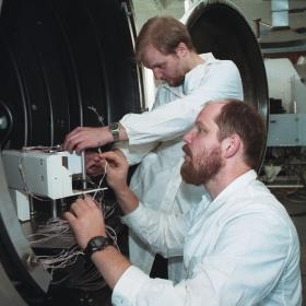 Дмитрий Анфимов (на переднем плане) и Максим Литвак (на заднем плане) готовят летный образец прибора ХЕНД миссии «Марс-Одиссей» (NASA) к термовакуумным испытаниям в ИКИ РАН. Июнь 2000 г. Фото ИКИ РАН