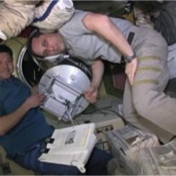 Космонавты О. Кононенко и А. Шкаплеров устанавливают контейнер с МС «Чибис-М» на ТГК «Прогресс». Фото ПАО «РКК «Энергия» им. С. П. Королёва»